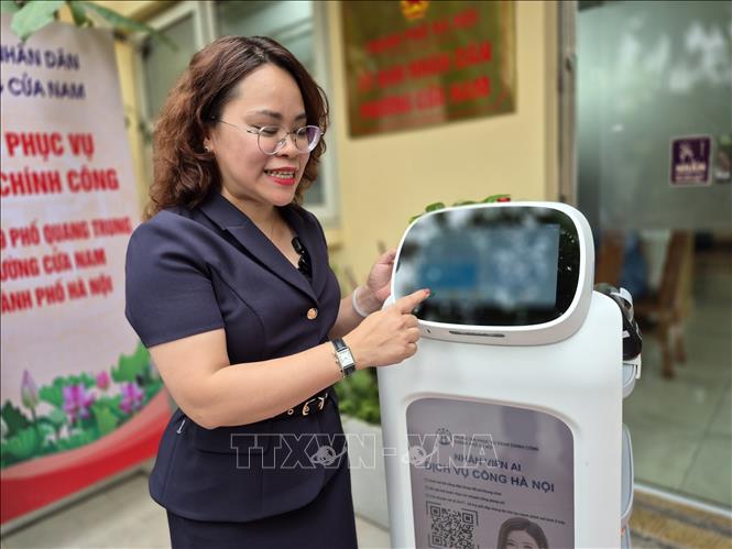 Bà Trịnh Ngọc Trâm, Phó Chủ tịch UBND phường Cửa Nam giới thiệu những tính năngưu việt của Robot AI. Ảnh: Nguyễn Thắng/ TTXVN