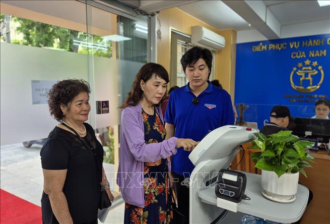Người dân trải nghiệm Robot AI áp dụng công nghệ trí tuệ nhân tạo hỗ trợ thựchiện các thủ tục hành chính. Ảnh: Nguyễn Thắng/TTXVN