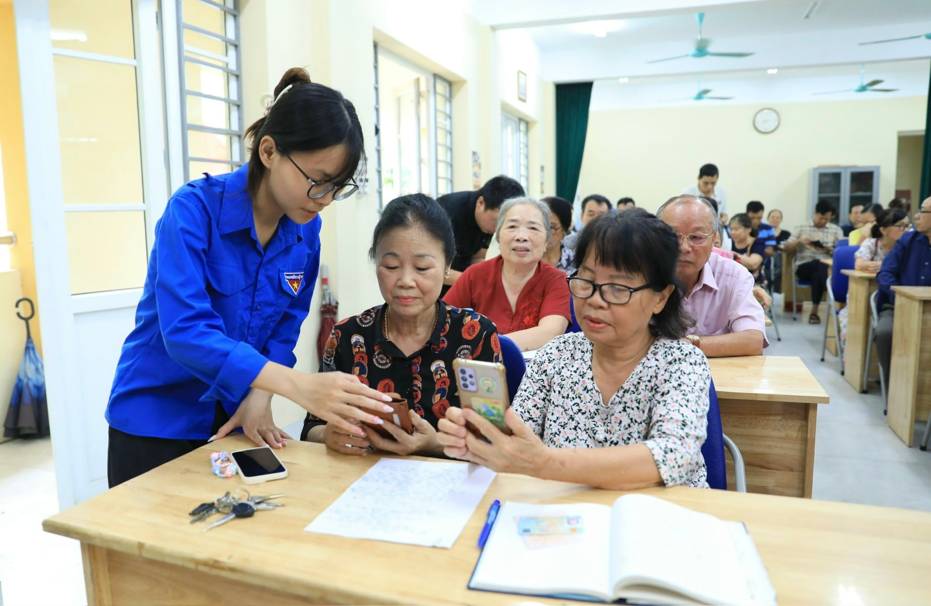 Đoàn viên, thanh niên phường Tây Hồ hướng dẫn cán bộ, đảng viên cài đặt ứng dụng thực hiện thủ tục hành chính Đảng. Ảnh: Quang Thái
