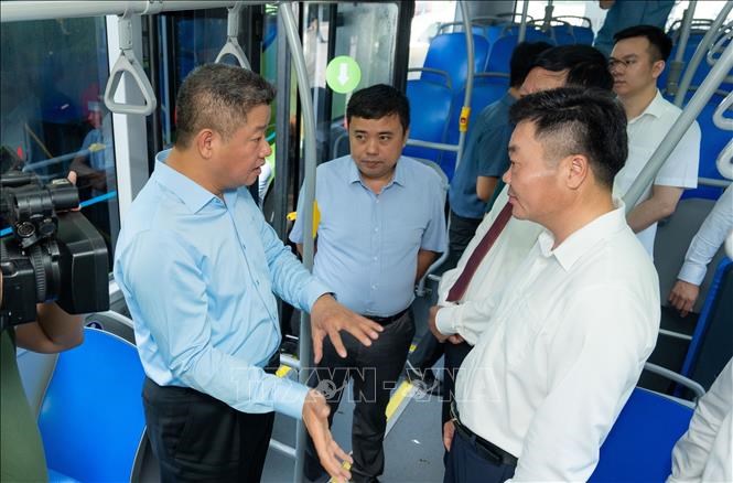 Phó Chủ tịch UBND thành phố Hà Nội Nguyễn Mạnh Quyền trao đổi với các đơn vịliên quan nhằm nâng cao chất lượng phục vụ hành khách trên tuyến xe buýt điện.Ảnh: TTXVN phát