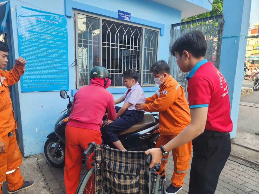 Thí sinh Xuân Triều được các tình nguyện viên tiếp sức tại điểm thi hỗ trợ dichuyển vào khu vực phòng thi.