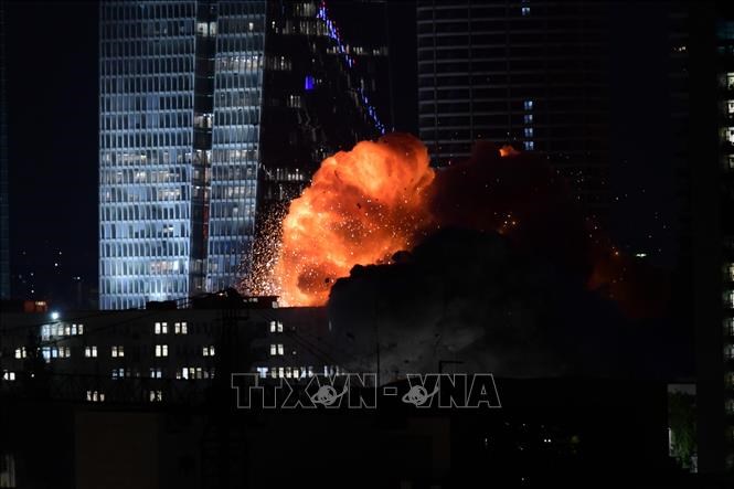 Khói lửa bốc lên từ toà nhà bị trúng tên lửa của Iran tại Tel Aviv, Israel tối14.6.2025. Ảnh: THX/TTXVN