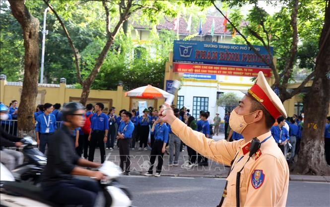 Cảnh sát giao thông hướng dẫn người dân, thí sinh tại địa điểm thi trường THPTPhan Đình Phùng (Hà Nội). Ảnh: Văn Điệp/TTXVN