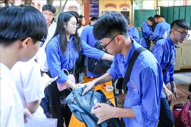 Thanh niên tình nguyện hỗ trợ thí sinh gửi đồ bên ngoài phòng thi tại điểmtrường THPT Trần Phú (quận Hoàn Kiếm). Ảnh: Khánh Hoà/TTXVN
