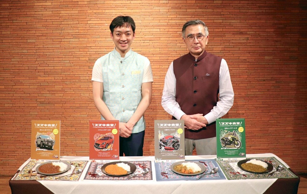 Chủ tịch Suzuki Motor Corp. Toshihiro Suzuki (bên phải) giới thiệu món cà richay Ấn Độ đóng gói mới. Ảnh: Kyodo