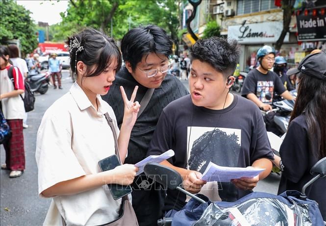 Thí sinh trao đổi sau khi hoàn thành bài thi môn Ngoại ngữ tại điểm trường THPTchuyên Chu Văn An (quận Tây Hồ, Hà Nội). Ảnh: Khánh Hoà/TTXVN