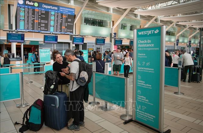 Hành khách tại quầy làm thủ tục của hãng hàng không WestJet ở sân bay quốc tếVancouver, Richmond, British Columbia, Canada. Ảnh: THX/TTXVN
