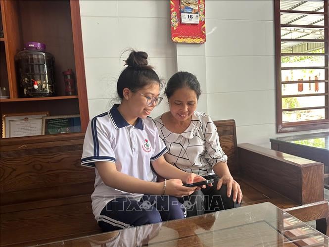 Em Nguyễn Đoàn Khánh Ly (trái), học sinh lớp 12 Hóa, trường THPT Chuyên Hà Tĩnh,xem điểm thi tốt nghiệp THPT năm 2025. Ảnh: TTXVN phát