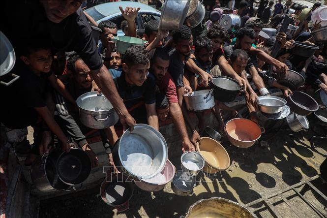 Người dân Palestine chờ nhận thức ăn cứu trợ tại thành phố Gaza, ngày 24.7.2025.Ảnh: THX/TTXVN