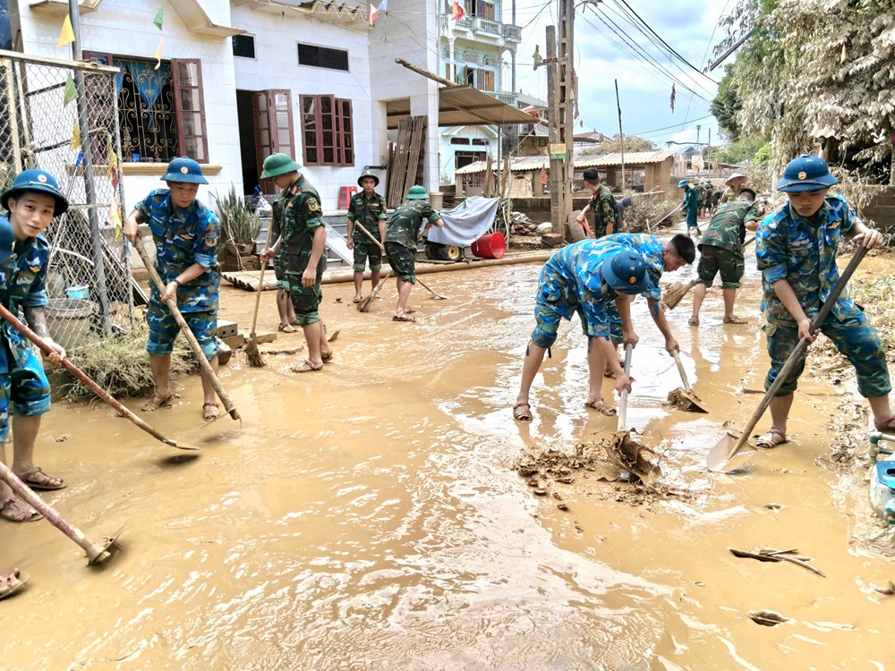 Bộ đội giúp dân dọn dẹp bùn đất, vệ sinh trường học  - ảnh 1
