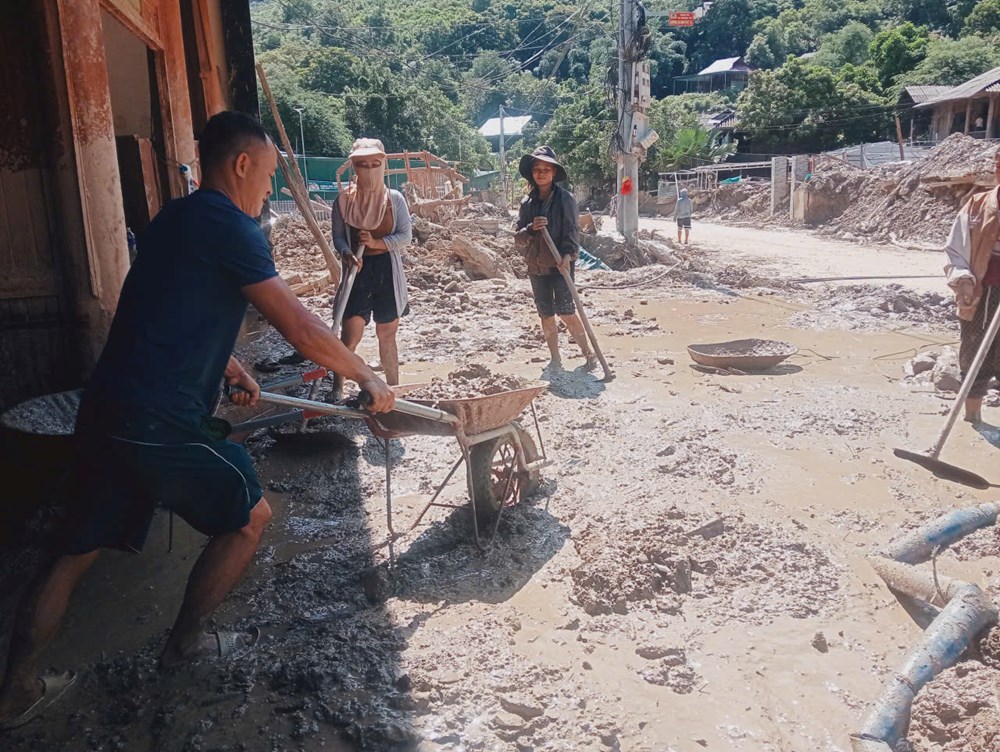 Người dân bản Na Mương (Lào) sang biên giới Nghệ An giúp khắc phục thiên tai - ảnh 1