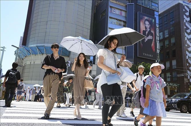 Người dân che ô tránh nắng nóng tại Tokyo, Nhật Bản năm 2024. Ảnh: Kyodo/TTXVN