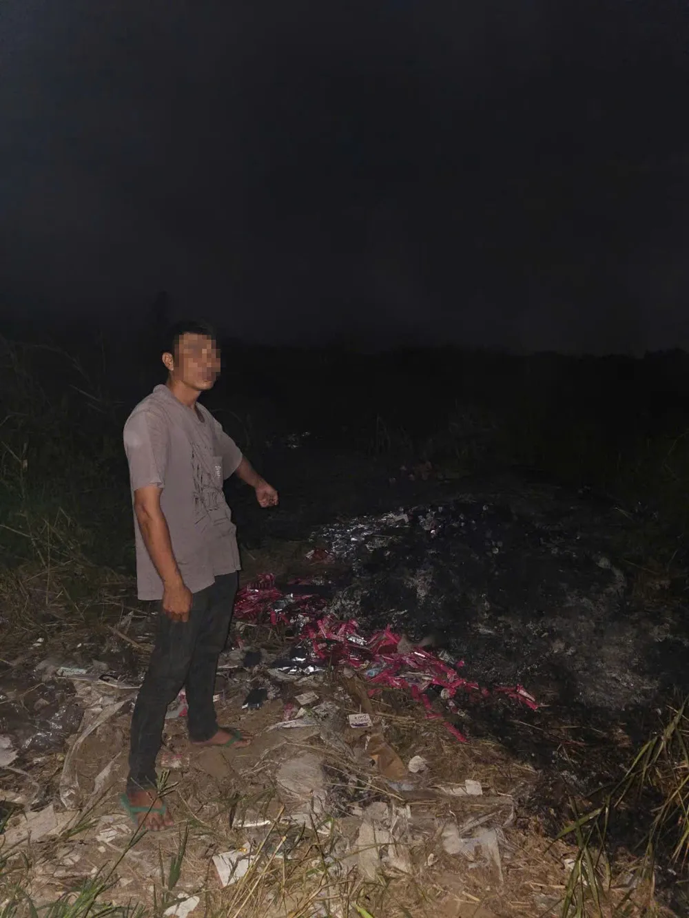 L. chỉ địa điểm bãi đất đổ bỏ và đốt số thực phẩm chức năng giả. Ảnh: CA