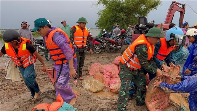Các lực lượng khắc phục sự cố vỡ đê. Ảnh: TTXVN phát