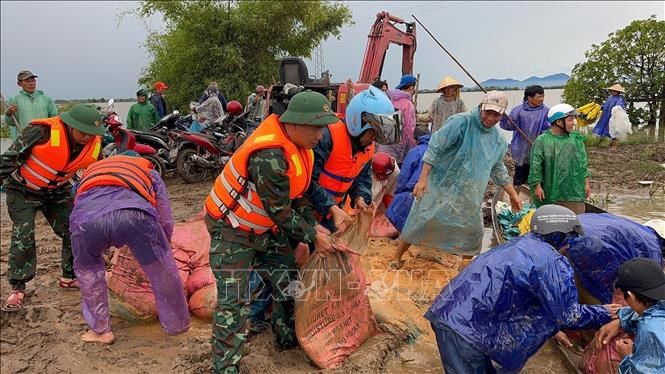 Các lực lượng khắc phục sự cố vỡ đê. Ảnh: TTXVN phát