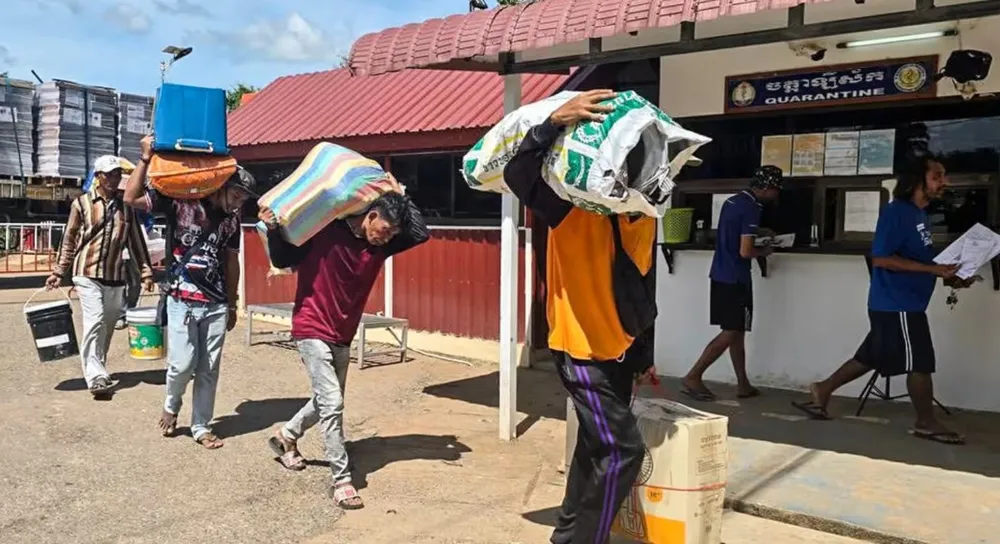 Lao động người Campuchia vận chuyển hàng qua biên giới tại trạm kiểm soát Phnom Dey, tỉnh Battambang, Campuchia. Ảnh: NATIONAL TELEVISION CAMBODIA