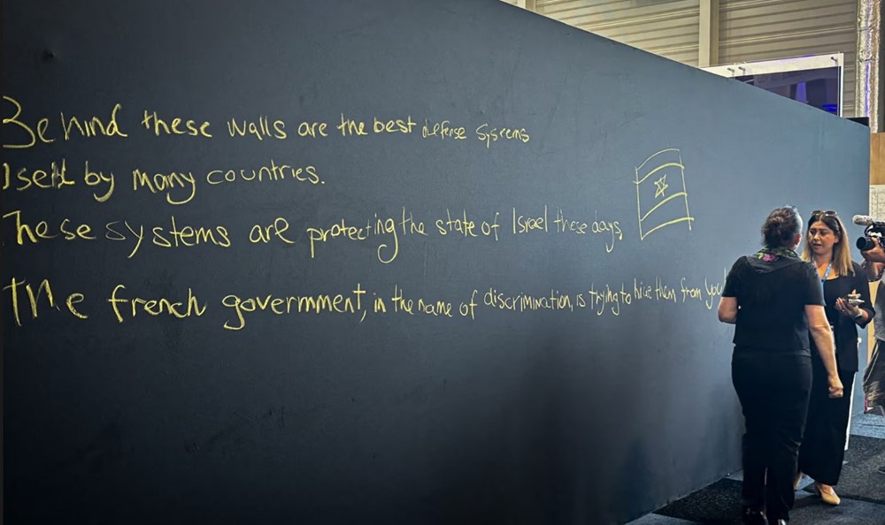 Một tấm bảng có hình vẽ graffiti tại gian hàng của Israel tại triển lãm hàng không Paris. Ảnh: AFP/Getty