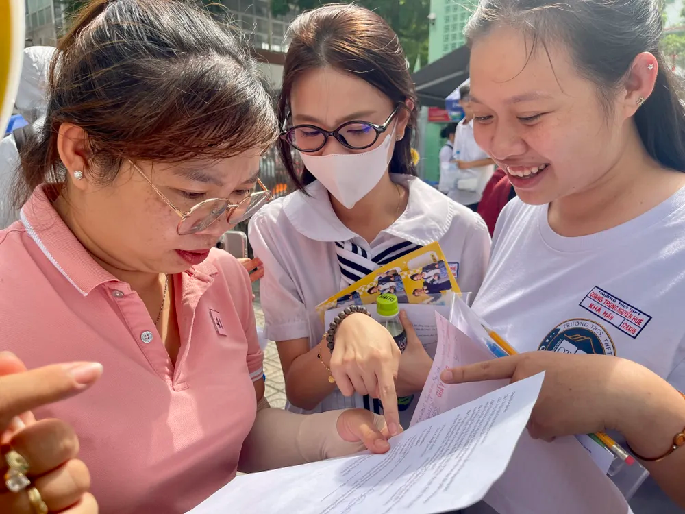 Các thí sinh cùng giáo viên Trường THCS - THPT Quang Trung Nguyễn Huệ trao đổi, so đáp án sau khi hoàn thành môn Ngữ văn tại điểm thi Trường TH Thực hành Sài Gòn, quận 5, TPHCM. Ảnh: Hoàng Hùng