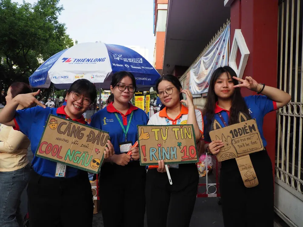 Đội ngũ tình nguyện viên trước điểm thi Trường THCS Colette động viên thí sinh hoàn thành tốt bài thi cuối. Ảnh: THU TÂM