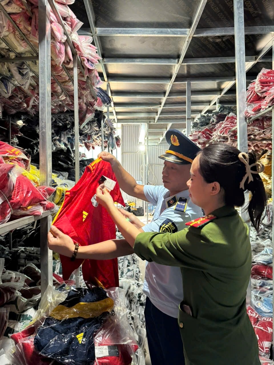 Lực lượng chức năng phát hiện lượng lớn quần áo giả mạo nhãn hiệu nổi tiếng. Ảnh: Mạnh Hùng