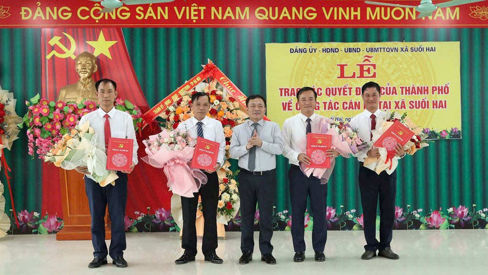 Lãnh đạo thành phố trao quyết định và tặng hoa chúc mừng lãnh đạo xã Suối Hai. Ảnh: Thu Duyên