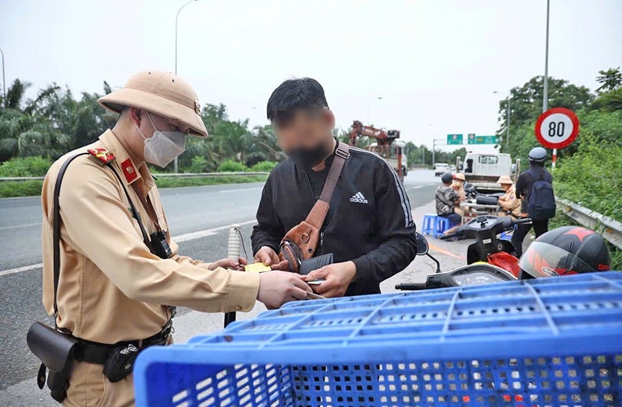 Cảnh sát giao thông (Công an thành phố Hà Nội) kiểm tra một trường hợp vi phạm tại Đại lộ Thăng Long. Ảnh: Dương Hiệp