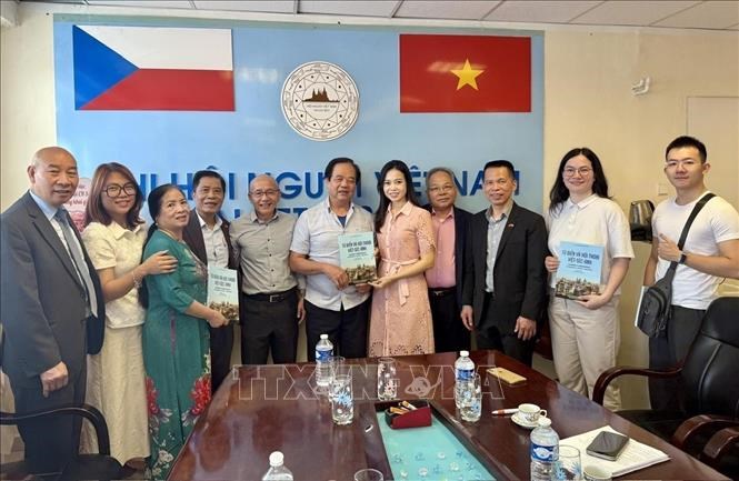 Dịch giả Nguyễn Quyết Tiến ( thứ 6 từ trái sang) trao tặng Trung tâm bộ sách từ điển và hội thoại Việt – Séc – Anh do chính ông biên soạn, đồng thời cam kết dịch miễn phí các tác phẩm thơ tiếng Việt sang tiếng Séc để phục vụ công tác giảng dạy.