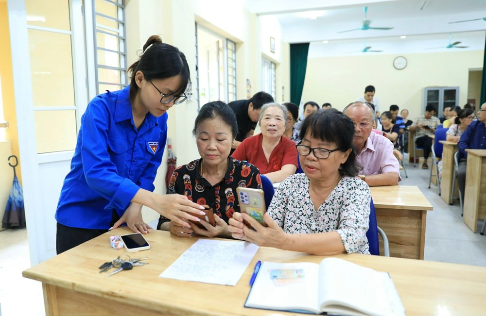 Đoàn viên, thanh niên phường Tây Hồ hướng dẫn cán bộ, đảng viên cài đặt ứng dụng thực hiện thủ tục hành chính Đảng. Ảnh: Quang Thái