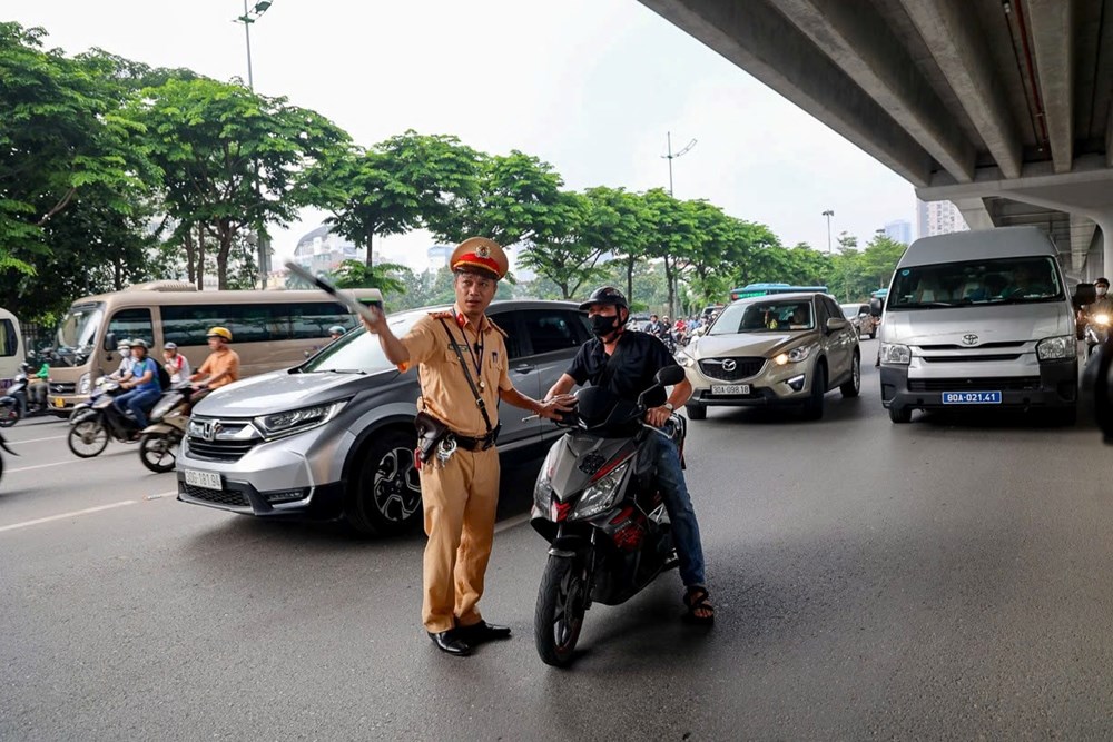 Cảnh sát giao thông nhắc nhở người điều khiển phương tiện vi phạm làn đường. Ảnh: TN