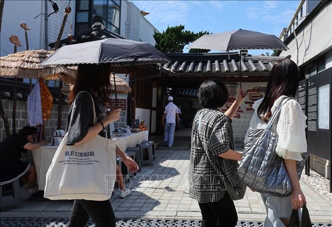 Người dân di chuyển dưới trời nắng nóng tại Seoul, Hàn Quốc. Ảnh: Yonhap/TTXVN