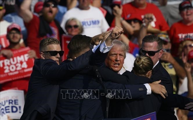 Ông Donald Trump được mật vụ Mỹ hộ tống rời khỏi bục diễn thuyết trong cuộc vận động tranh cử ở thành phố Butler, bang Pennsylvania, sau khi xảy ra vụ ám sát ngày 13.7.2024. Ảnh: Getty Images/TTXVN