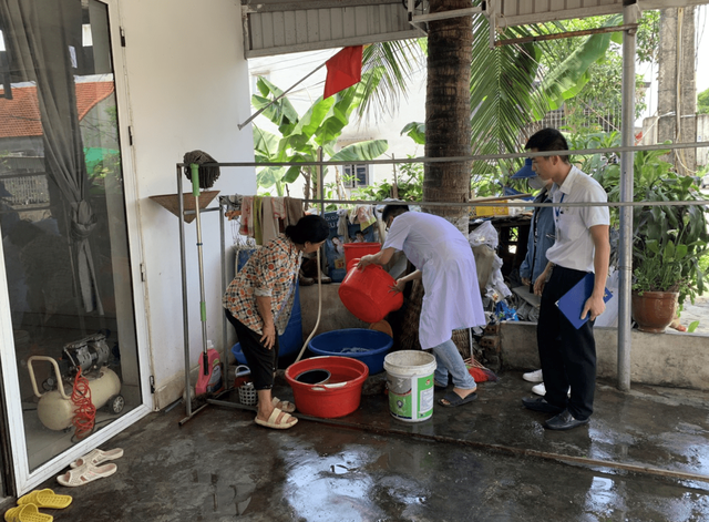 Nhân viên y tế của Trung tâm y tế Tp. Móng Cái tuyên truyền, hướng dẫn người dân xử lý các vật dụng chứa nước để muỗi không vào đẻ trứng.
