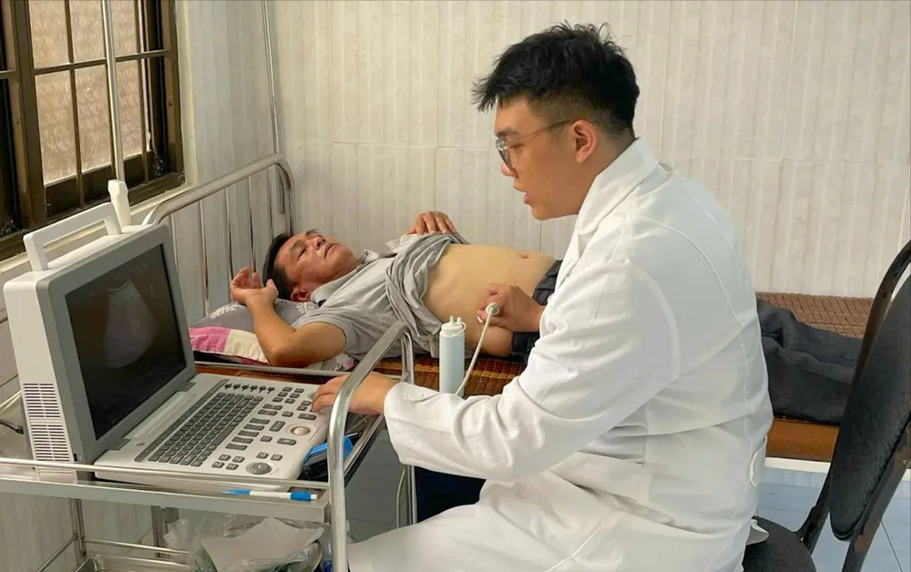 Thượng úy, bác sĩ quân y Bùi Nguyễn Thanh Nam khám, điều trị cho người bệnh tại Trung tâm Y tế quân dân y Côn Đảo. Ảnh: TRÚC GIANG