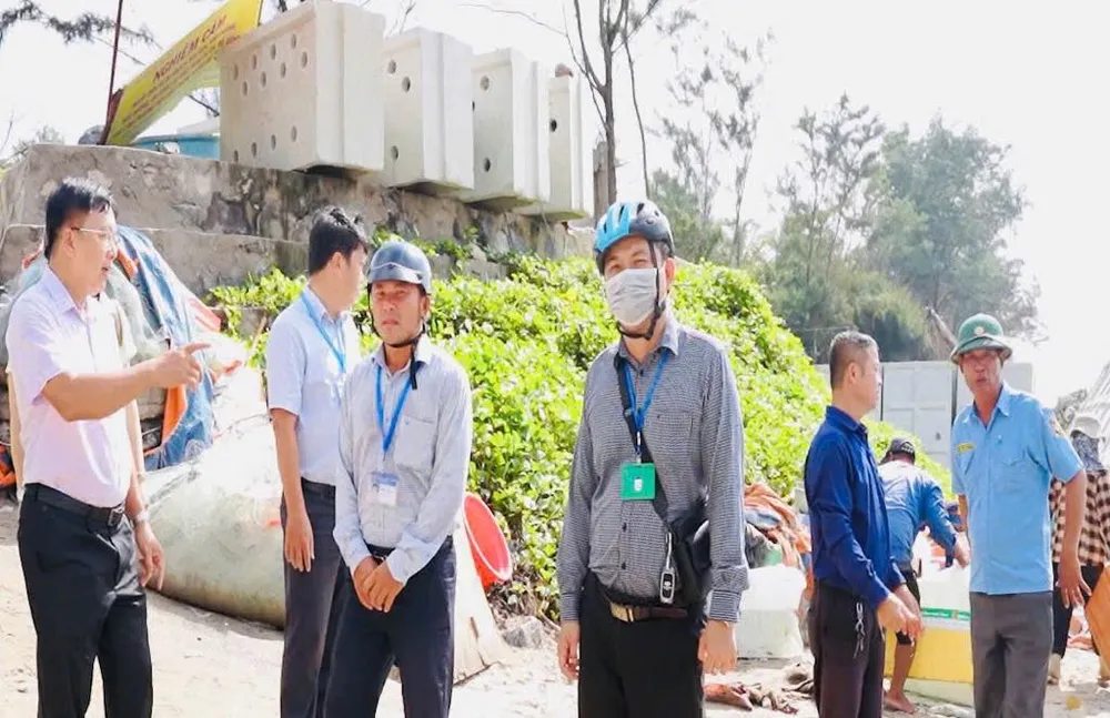 Bí thư Đảng ủy phường Rạch Dừa Nguyễn Phúc Hoàng (bìa trái) trực tiếp chỉ đạo xử lý chợ tự phát trên bãi biển Thủy Tiên, sáng 15-7. Ảnh: QUANG VŨ