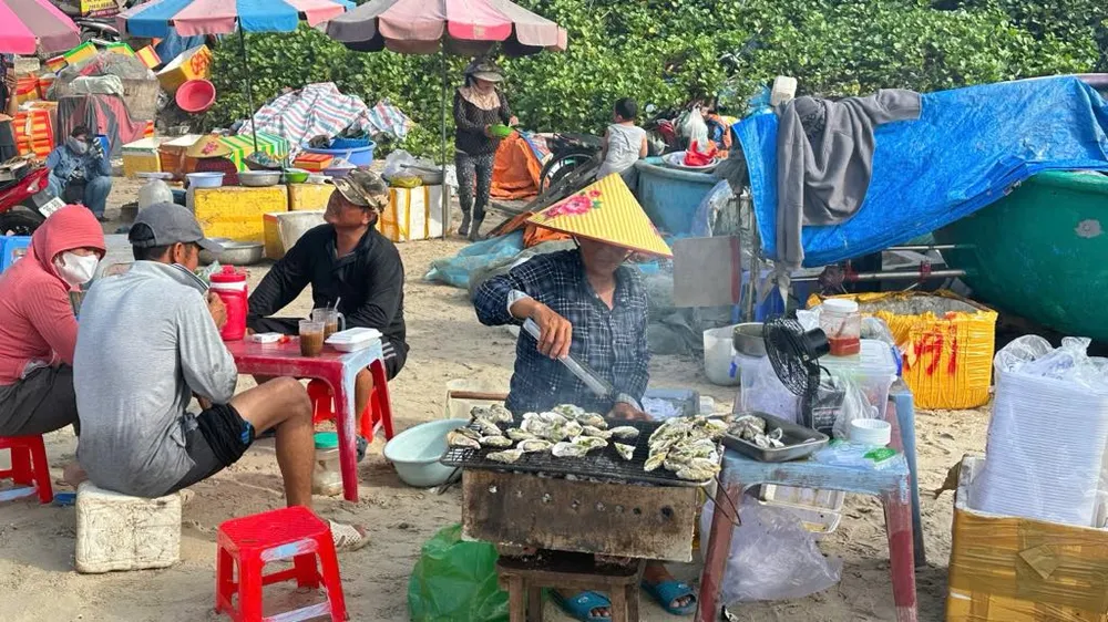 Người dân chế biến thức ăn phục vụ khách ngay trên bãi biển. Ảnh: QUANG VŨ