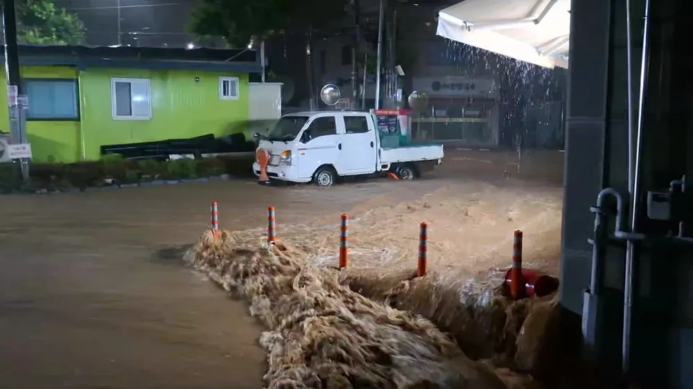 Nước cuộn đục ngầu ở TP Seosan, Hàn Quốc ngày 17.7. Ảnh: YONHAP