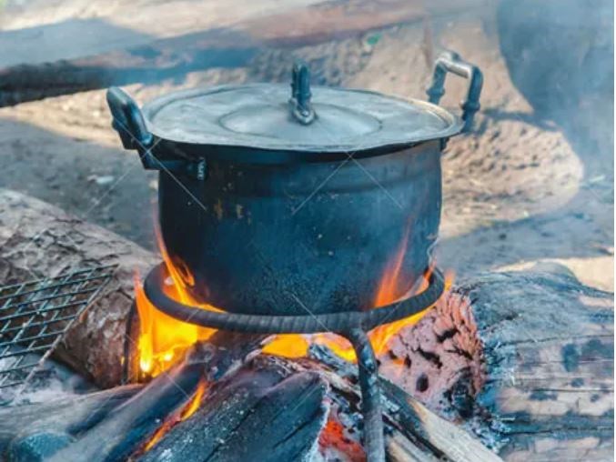 Sử dụng củi, than và các loại nhiên liệu thô sơ để nấu ăn, một thực trạng gây ônhiễm không khí nghiêm trọng và đe dọa sức khỏe cộng đồng. Ảnh: tribuneonlineng.com