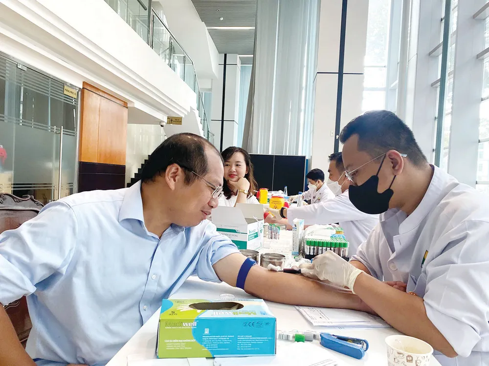 Nhân viên Phòng khám Đa khoa Hòa Hảo (TPHCM) lấy mẫu máu xét nghiệm cho người dân