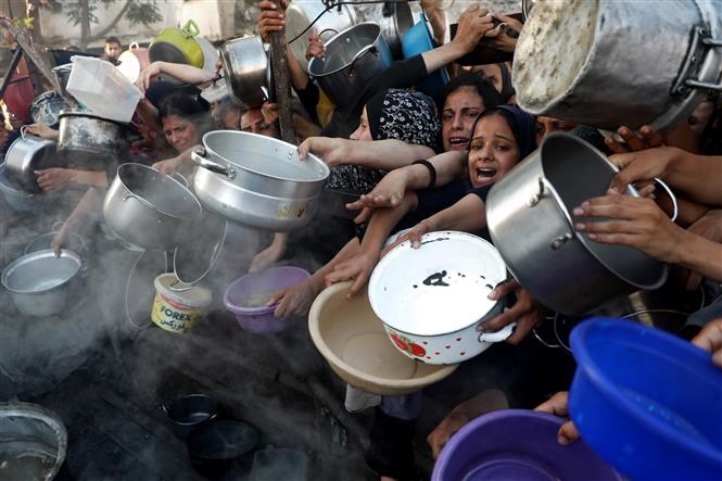 Người dân Palestine chờ được phát thực phẩm cứu trợ tại Gaza. Ảnh: THX/TTXVN