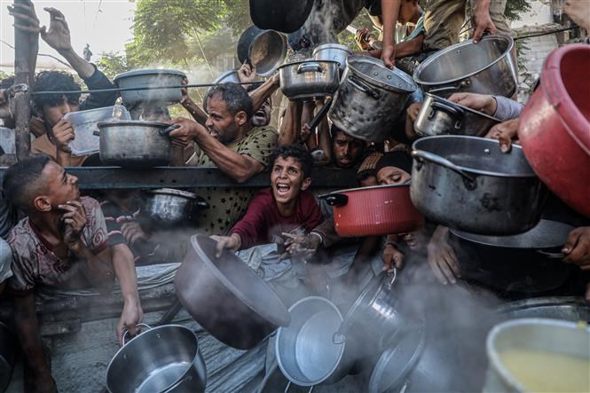 Người dân Palestine chờ nhận thức ăn cứu trợ ở thành phố Gaza. Ảnh: THX/TTXVN