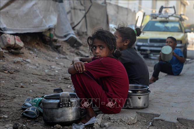 Trẻ em ngồi chờ nhận thức ăn cứu trợ ở thành phố Gaza. Ảnh minh họa: THX/TTXVN