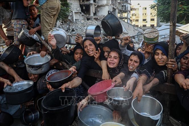 Người dân Palestine chờ nhận thức ăn cứu trợ tại một trung tâm từ thiện ở thành phố Gaza, ngày 14.7.2025. Ảnh: THX/TTXVN