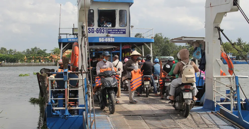 Nhân viên bến đò An Sơn, TPHCM phát áo phao cho khách đi phà. Ảnh: XUÂN TRUNG