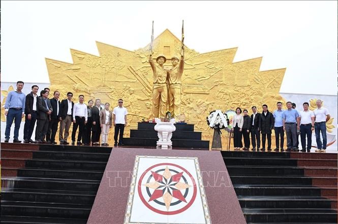 Các đại biểu chụp ảnh chung tại chân Tượng đài Liên minh chiến đấu Lào – Việt Nam ở huyện Paksong, tỉnh Champasak. Ảnh: TTXVN phát