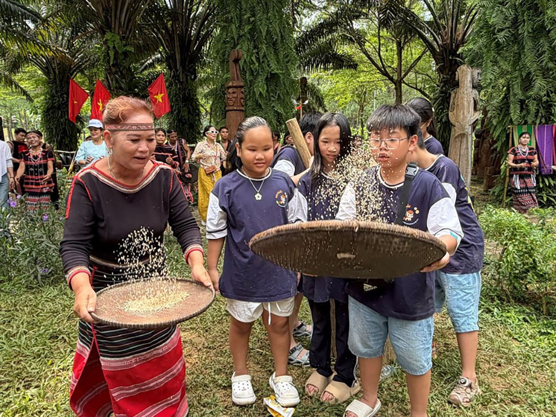 Du khách trải nghiệm sàng gạo cùng đồng bào