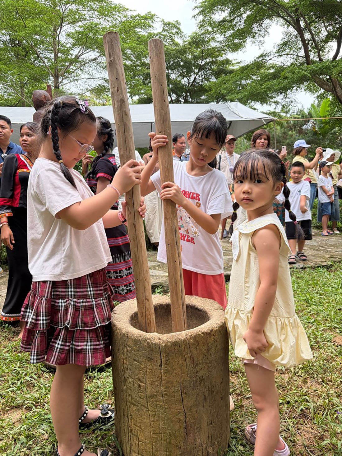 Trẻ em hào hứng trải nghiệm giã gạo tại không gian Tây Nguyên