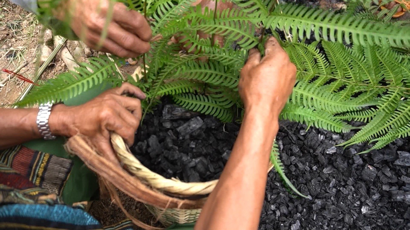 Già làng chủ trì nghi thức đốt than trong lễ ăn than