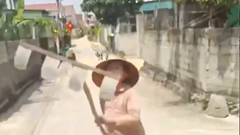 Người phụ nữ phơi lúa giữa đường cầm cào chặn đầu xe tải 