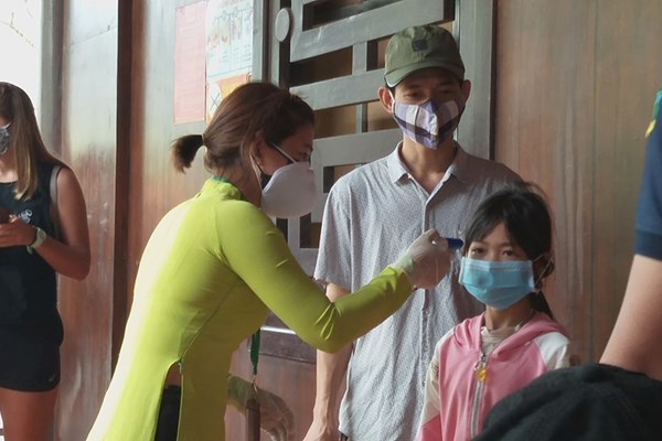 Du khách đến Tràng An vui vẻ mua khẩu trang trước khi vào tham quan - Anh 2