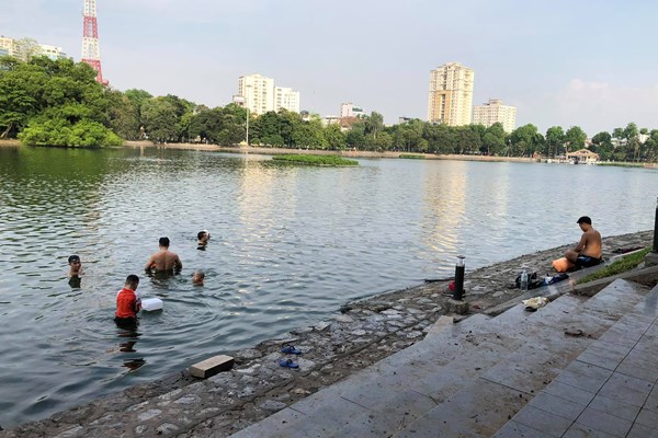 Hà Nội: Người dân mạo hiểm “vượt rào” hóng gió, tắm giải nhiệt tại Hồ Tây - Anh 10